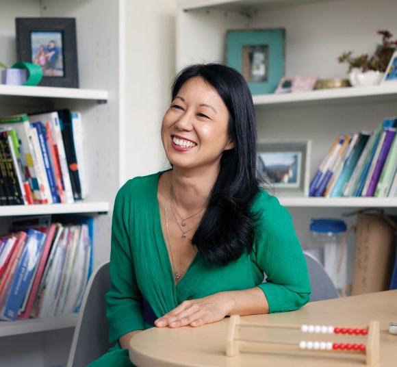 Cathery Yeh Sitting at Desk Smiling