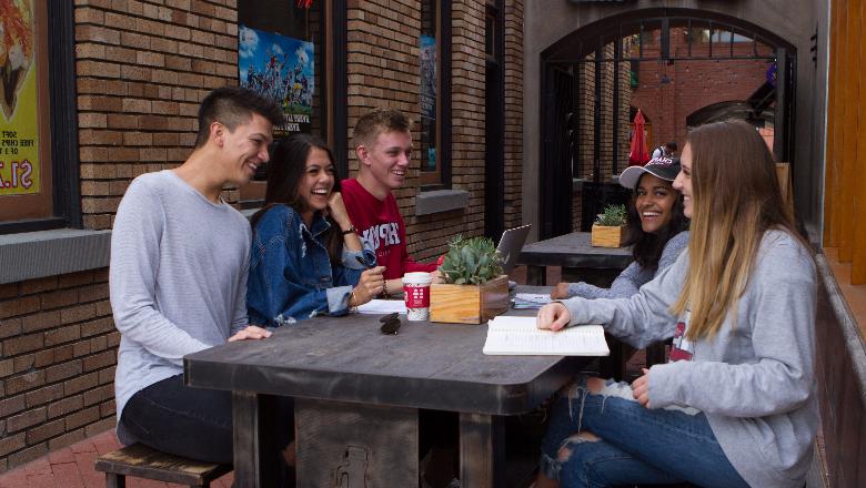 澳门威尼斯人app下载大学 students sitting outside a restaurant in Old Towne Orange, CA